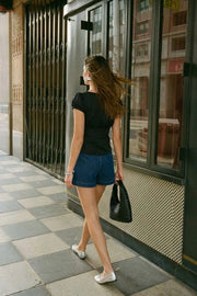 Blusa corta de rayas, fit ajustado, manga corta abullonada con rib elástico en borde, cuello redondo y cierre frontal con botones. Detalle de cortes y plisados decorativos frontales.