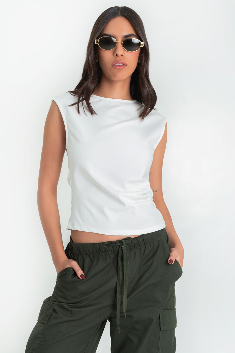 Blusa básica de fit recto, sin mangas, cuello redondo y plisados decorativos en costado.