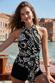 Blusa estampada de fit recto, halter con cuello fluido, sin mangas, lazo amarrable en cintura, cierre posterior con botón y ojal.
