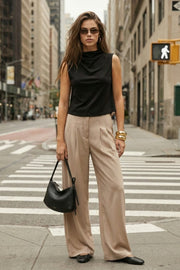 Blusa sin mangas de fit recto, cuello mock con detalles plisados y cierre posterior con botón y ojal.