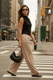 Blusa sin mangas de fit recto, cuello mock con detalles plisados y cierre posterior con botón y ojal.