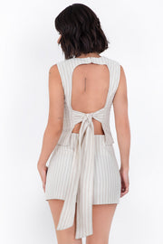 Blusa corta de estampado rayas, fit ajustado, sin mangas, cuello redondo, pinzas frontales y cut out en espalda con lazo amarrable posterior. Cierre posterior con broche oculto.