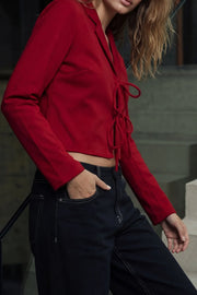 Blusa corta de fit fluido, manga larga, escote v con solapa y cierre frontal con lazos amarrables.