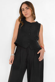 Blusa corta fluida de fit recto, cuello redondo, sin mangas y cierre frontal con hilera de botones. Detalle de abertura frontal en bajo.