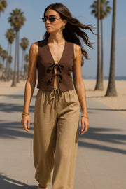 Blusa corta de fit recto, escote v, sin mangas y cierre frontal con lazos amarrables. Detalle de vivos decorativos frontales.