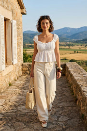 Blusa corta de escote v redondeado y manga corta con rib elástico y olanes en borde, elástico en cintura, peplum con olanes en bajo y detalle de textura en tejido.
