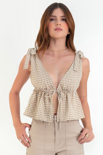 Blusa corta de estampado cuadros, escote v redondeado, plisado con lazo amarrable frontal, peplum con olanes en bajo y tirantes con nudo amarrable.