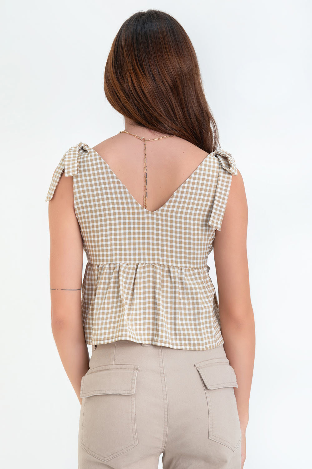 Blusa corta de estampado cuadros, escote v redondeado, plisado con lazo amarrable frontal, peplum con olanes en bajo y tirantes con nudo amarrable.