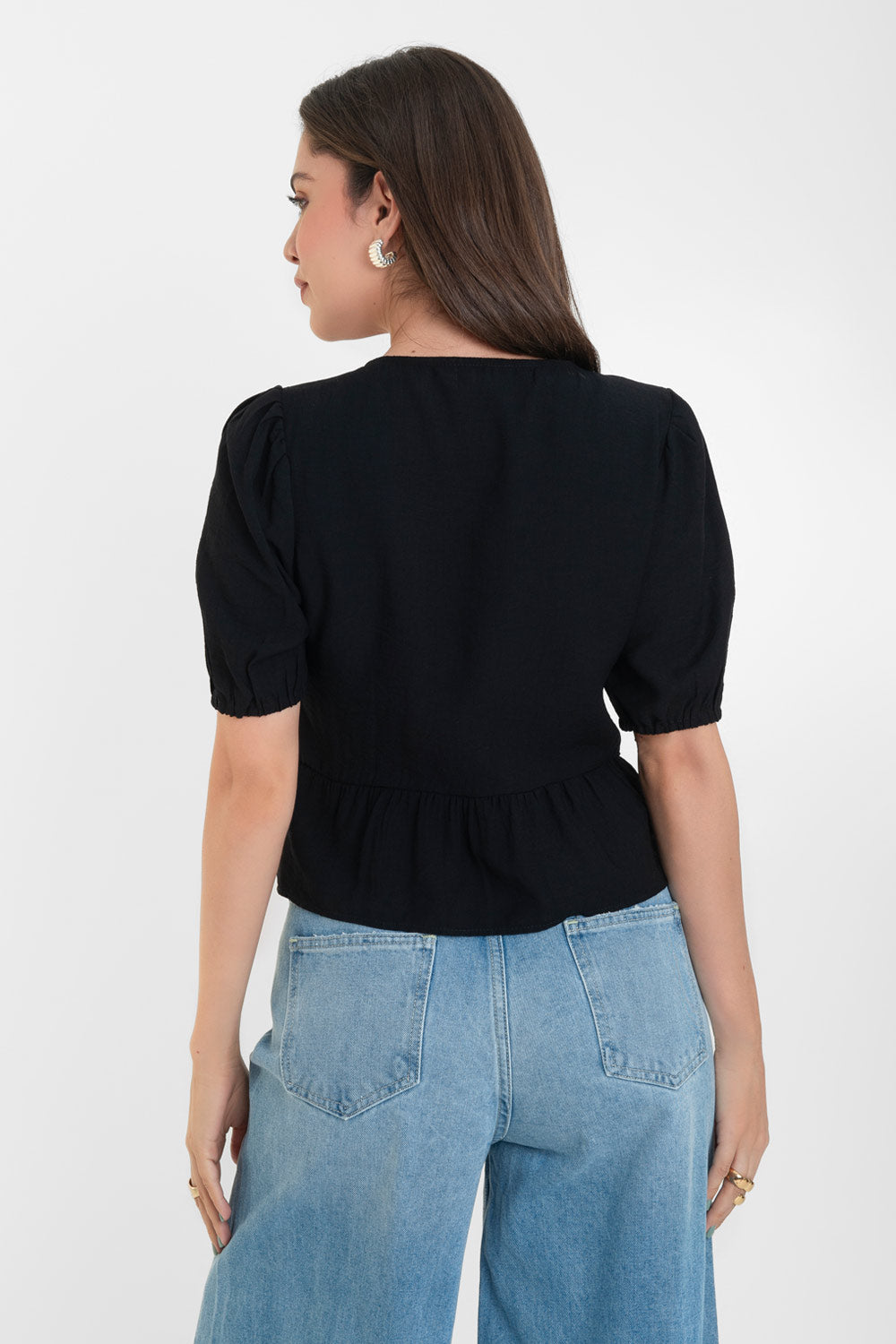 Blusa de manga corta abullonada con rib elástico en bordes, cuello redondo y cierre frontal con lazos amarrables. Detalle de peplum con olanes en bajo.