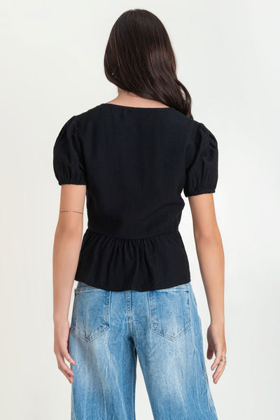 Blusa de manga corta abullonada con rib elástico en bordes, escote v y cierre frontal con lazos amarrables. Detalle de peplum con olanes en bajo.