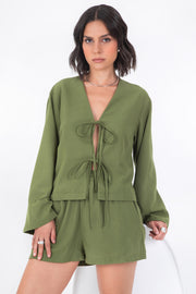 Blusa corta de fit recto, manga larga de puño amplio, escote v y cierre frontal con lazado amarrable.