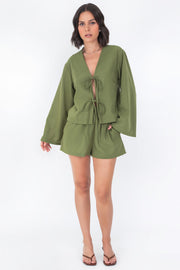 Blusa corta de fit recto, manga larga de puño amplio, escote v y cierre frontal con lazado amarrable.