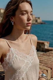 Blusa fluida larga de tirantes delgados ajustables, escote v con escote decorativo en contraste, cut out diagonal y bajo asimétrico frontal.