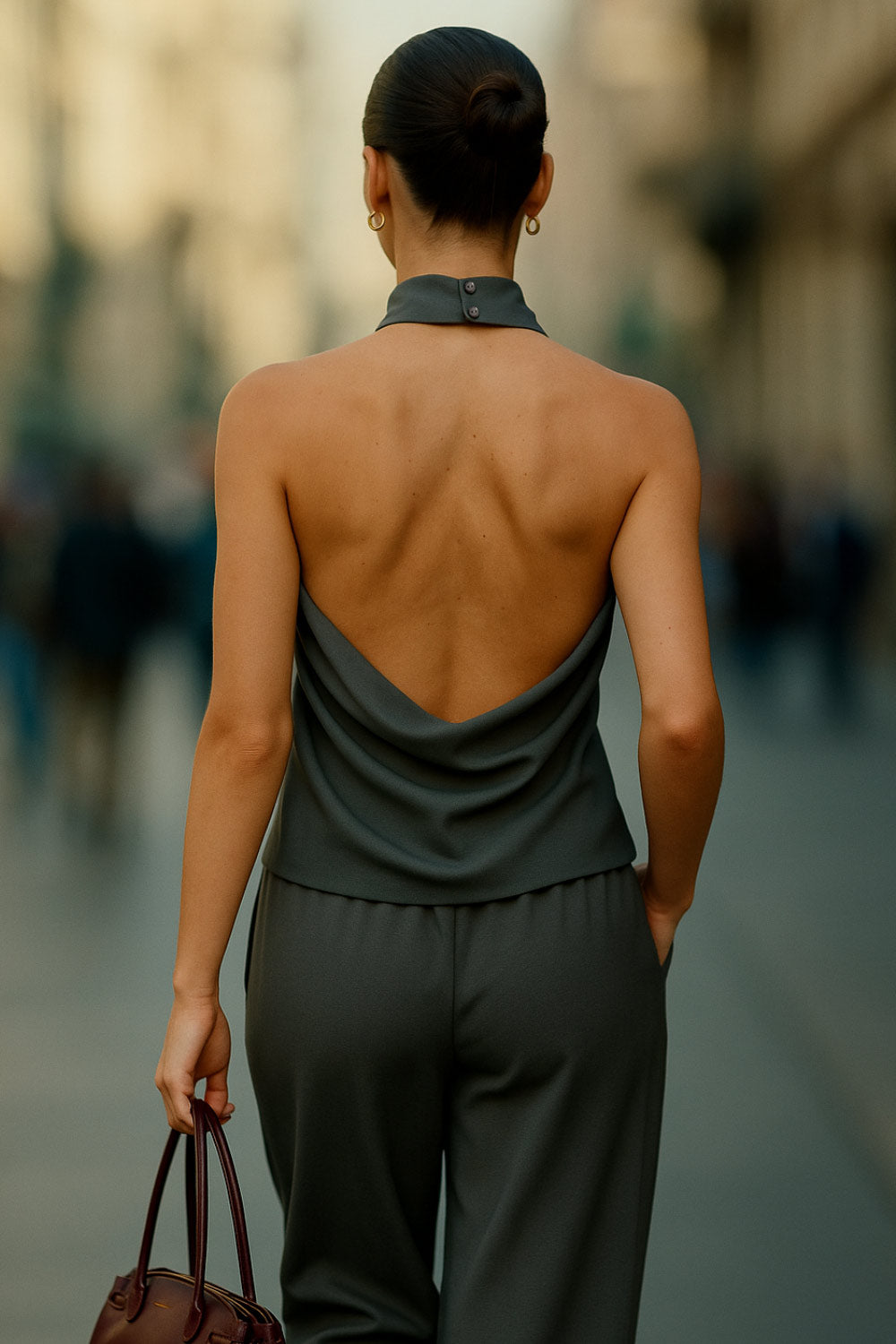 Blusa de cuello halter con escote fluido, sin mangas, escote en espalda, cierre posterior con botón y ojal.