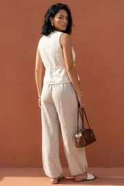 Blusa corta fluida de escote v, sin mangas, jareta en cintura y cierre frontal con lazos amarrables.