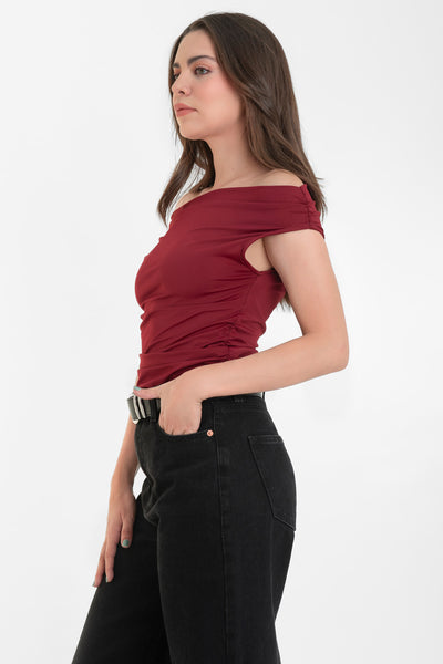 Blusa de fit ajustado, manga corta seguida con plisados en laterales, hombros descubiertos, plisados en costados y escote recto.