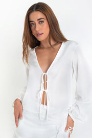 Blusa abierta de fit fluido, escote v, manga larga abullonada con rib elástico en puños y cierre frontal con lazo amarrable.