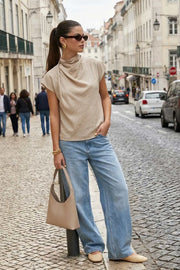 Blusa fluida de manga corta seguida, cuello mock seguido con plisados decorativos en hombro y cuello. Cierre posterior con botones y ojales.