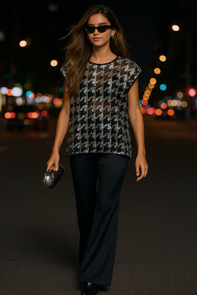 Blusa de mesh fluido, manga corta seguida, cuello redondo y detalle de estampado pata de gallo con lentejuelas.