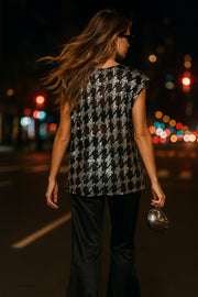 Blusa de mesh fluido, manga corta seguida, cuello redondo y detalle de estampado pata de gallo con lentejuelas.