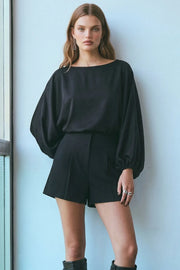 Blusa de fit fluido, cuello barco y manga larga abullonada con rib elástico en puños.