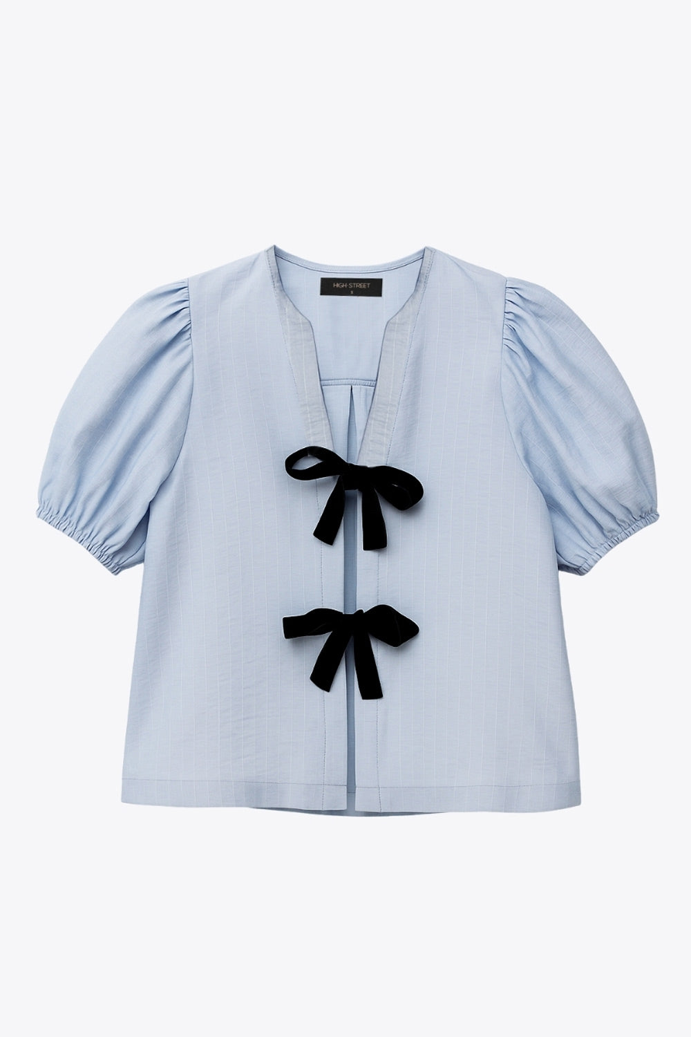 Blusa de fit fluido, estampado rayas, manga corta abullonada con rib elástico en bordes, cuello redondo y escote v. Cierre frontal con doble lazo amarrable en contraste y pinza amplitud en espalda.