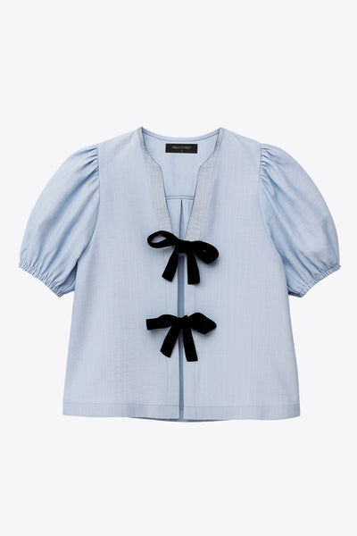 Blusa de fit fluido, estampado rayas, manga corta abullonada con rib elástico en bordes, cuello redondo y escote v. Cierre frontal con doble lazo amarrable en contraste y pinza amplitud en espalda.