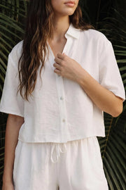 Camisa corta de fit recto, manga corta, cuello solapa, escote v y cierre frontal con hilera de botones.
