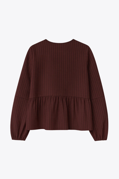 Blusa de fit fluido, manga larga abullonada con rib elástico en puños, escote v, plisados decorativos en hombros y peplum con olanes en bajo. Cierre frontal con hilera de botones.