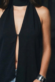 Blusa fluida de cuello alto halter, sin mangas, bajo asimétrico, escote frontal y en espalda.