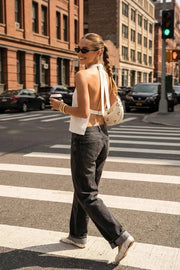 Blusa de fit fluido, cuello halter con nudo amarrable posterior, escote en espalda y cierre posterior con trabilla ajustable.