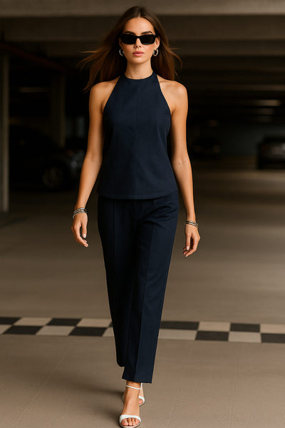 Blusa de fit fluido, cuello halter con nudo amarrable posterior, escote en espalda y cierre posterior con trabilla ajustable.