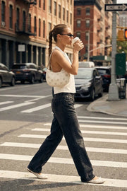 Blusa de fit fluido, cuello halter con nudo amarrable posterior, escote en espalda y cierre posterior con trabilla ajustable.