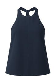 Blusa de fit fluido, cuello halter con nudo amarrable posterior, escote en espalda y cierre posterior con trabilla ajustable.