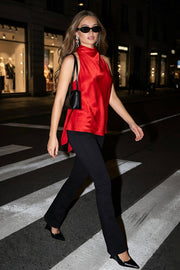 Blusa de fit fluido, sin mangas, cuello alto halter con plisados y nudo amarrable posterior.