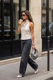 Blusa corta de fit fluido, sin mangas, estampado rayas, cuello halter fluido con plisados, escote en espalda y lazo amarrable posterior. Cierre posterior con botón y ojal.