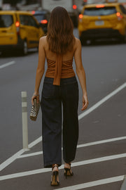 Blusa corta de cuello alto halter con lazo amarrable posterior, escote fluido con cut out frontal y en espalda.