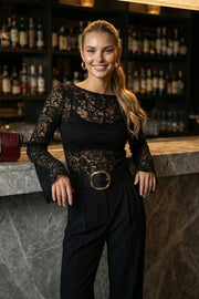 Blusa de encaje, fit ajustado, cuello barco, manga larga con puño amplio y detalle decorativo en bordes.
