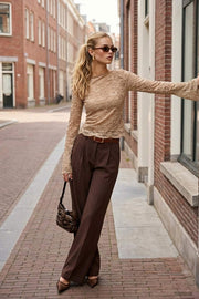 Blusa de encaje, fit ajustado, cuello barco, manga larga con puño amplio y detalle decorativo en bordes.