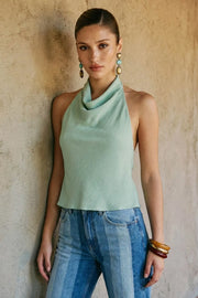 Blusa de cuello halter fluido, escote en espalda con lazo amarrable posterior, cierre con botón y ojal.