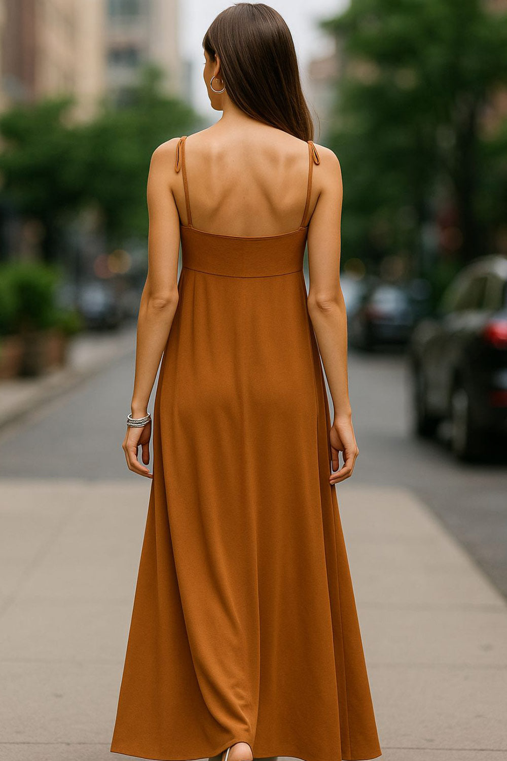 Blusa larga de fit fluido, tirantes delgados con nudo ajustable, escote v con cortes, abertura frontal y cierre con botón.