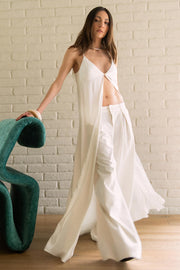 Blusa larga de fit fluido, tirantes delgados con nudo ajustable, escote v con cortes, abertura frontal y cierre con botón.