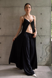 Blusa larga de fit fluido, tirantes delgados con nudo ajustable, escote v con cortes, abertura frontal y cierre con botón.