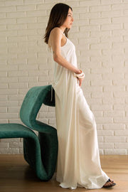 Blusa larga de fit fluido, tirantes delgados con nudo ajustable, escote v con cortes, abertura frontal y cierre con botón.