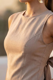 Blusa corta de fit ajustado, sin mangas, cuello redondo, pinzas frontales y cut out en espalda con lazo amarrable posterior. Cierre posterior con broche.