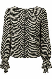 Blusa de estampado animal, fit fluido, manga larga abullonada con rib elástico y olanes en puños, cuello barco y escote fluido en espalda con lazo amarrable posterior.