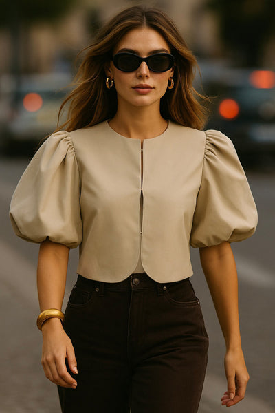 Blusa corta de fit recto, cuello redondo, manga corta amplia globo con volumen en borde, cierre frontal con broches ocultos y bajo curveado frontal.