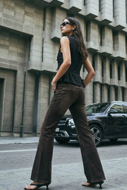 Blusa corta de fit ajustado, cuello mao, sin mangas y cierre frontal con lazos amarrables. Detalle de peplum con plisados y olanes en bajo.