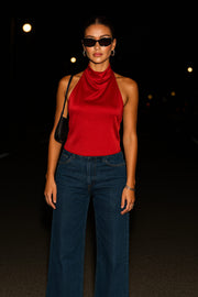 Blusa corta satinada de cuello halter con escote fluido, sin mangas y escote en espalda con tirantes delgados ajustables.