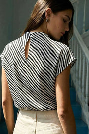 Blusa de estampado rayas, cuello alto fluido, plisados en hombros, manga corta seguida y fit recto. Cierre posterior con botón y ojal.